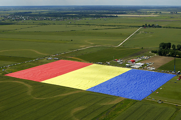 Workers arrange Romania's national flag during a Guinness World Record attempt for the world's biggest national flag in Clinceni